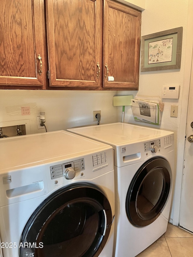 laundry room featuring cabinets, independent washer and dryer, and light tile patterned flooring