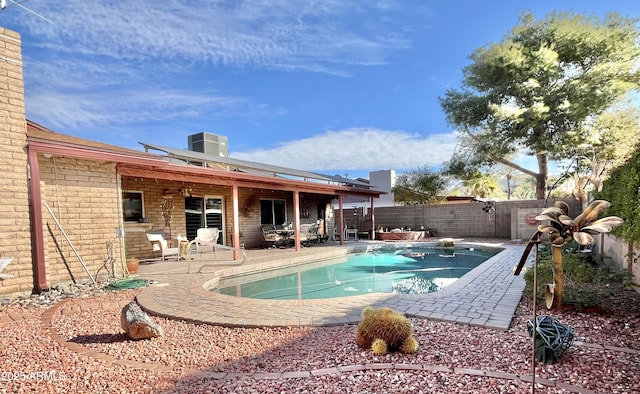 view of swimming pool with central air condition unit and a patio