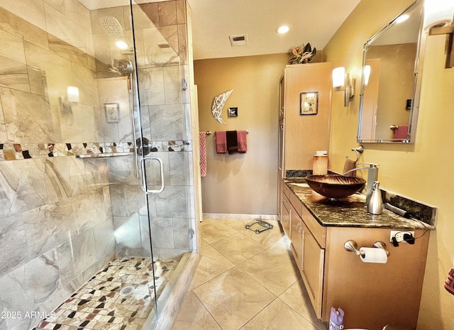 bathroom featuring tile patterned flooring, a shower with shower door, and vanity