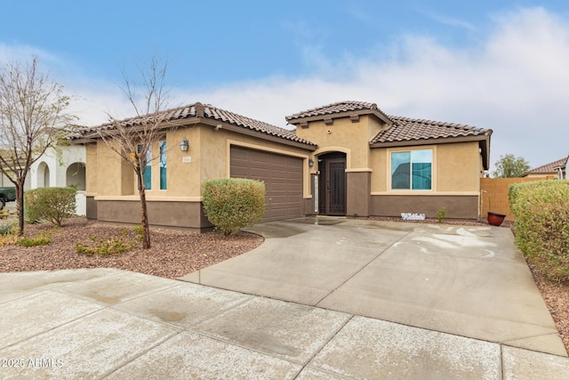 mediterranean / spanish home featuring a tile roof, stucco siding, an attached garage, fence, and driveway