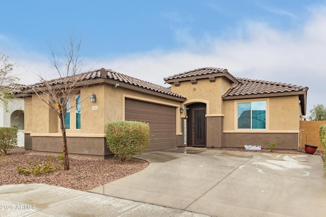 mediterranean / spanish-style house with a garage, fence, driveway, a tiled roof, and stucco siding