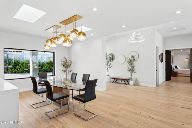 dining space featuring recessed lighting, a skylight, baseboards, and light wood-style floors