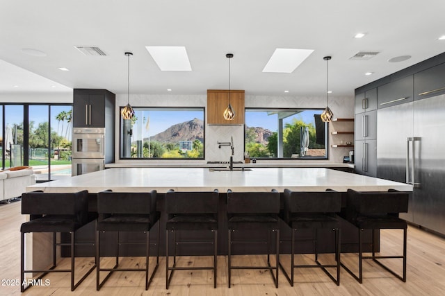 kitchen featuring decorative backsplash, visible vents, a skylight, appliances with stainless steel finishes, and modern cabinets