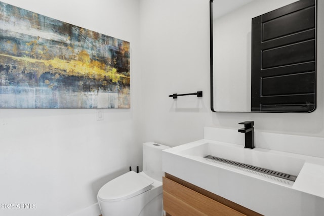 half bathroom with vanity and toilet