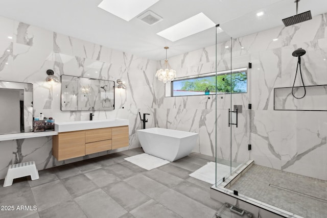 full bath with vanity, visible vents, tile walls, a marble finish shower, and a skylight