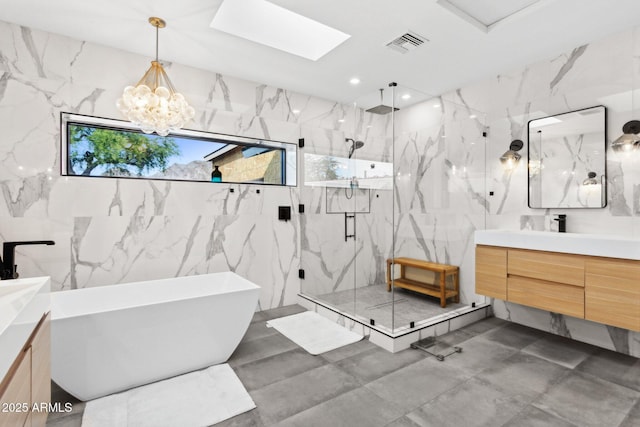 bathroom with vanity, a marble finish shower, visible vents, and tile walls