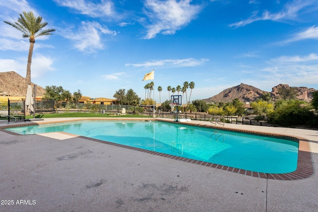 view of swimming pool featuring a fenced in pool, a mountain view, a patio, and fence