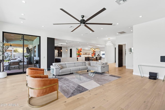 living area with visible vents, light wood finished floors, and ceiling fan
