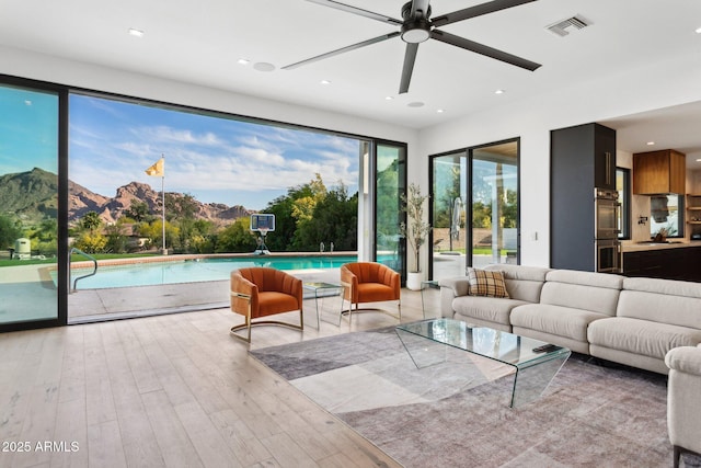 living room with visible vents, recessed lighting, a mountain view, hardwood / wood-style flooring, and a ceiling fan