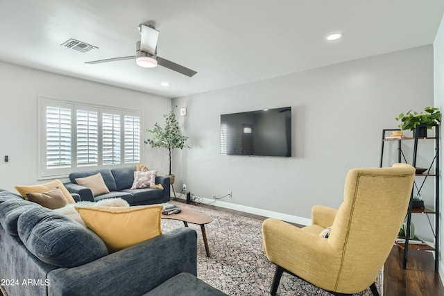 living room with ceiling fan and dark wood-type flooring