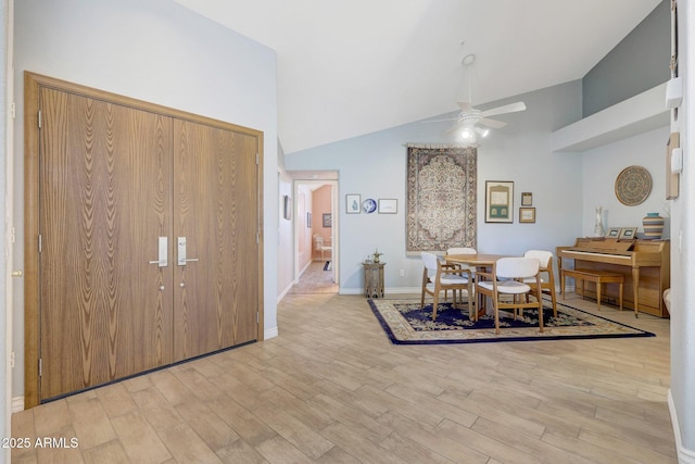 dining room featuring ceiling fan, light hardwood / wood-style flooring, and high vaulted ceiling