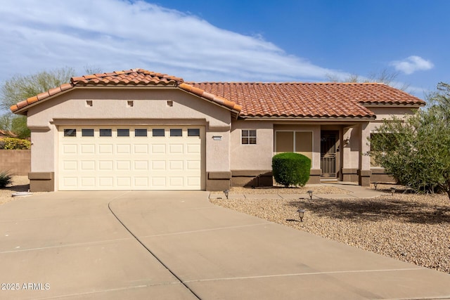 mediterranean / spanish-style house featuring a garage, driveway, a tiled roof, and stucco siding