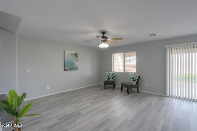 living area featuring ceiling fan and light hardwood / wood-style flooring