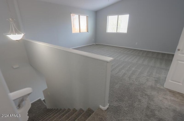 interior space with carpet and vaulted ceiling