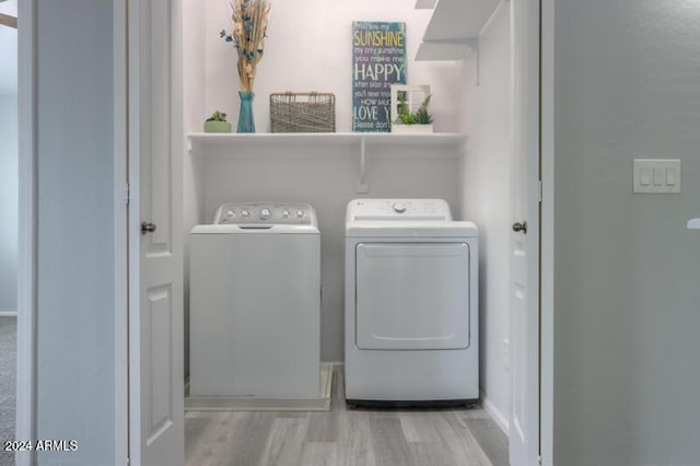 washroom with separate washer and dryer and light wood-type flooring