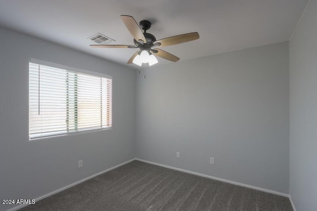 unfurnished room with ceiling fan and dark colored carpet