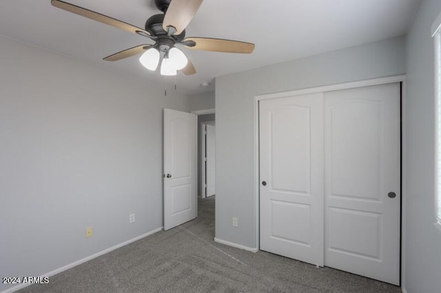 unfurnished bedroom with ceiling fan, light carpet, and a closet