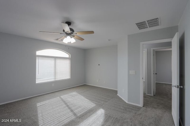 spare room with ceiling fan and light carpet