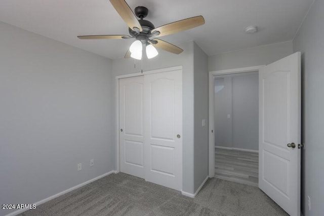 unfurnished bedroom with a closet, light colored carpet, and ceiling fan