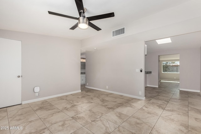 spare room featuring baseboards, visible vents, and a ceiling fan