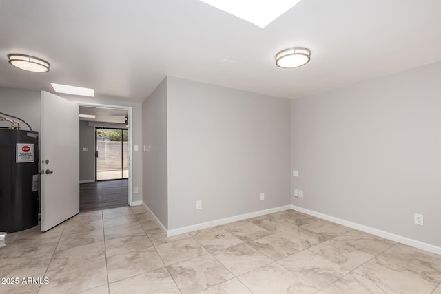 unfurnished room with a skylight, water heater, and baseboards