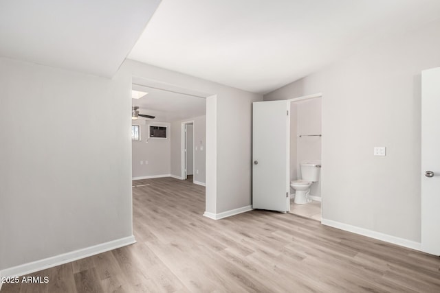 spare room featuring light wood finished floors, baseboards, and a ceiling fan