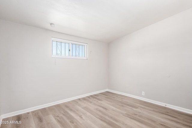 empty room featuring light wood finished floors and baseboards