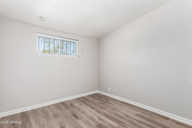 empty room featuring baseboards and wood finished floors