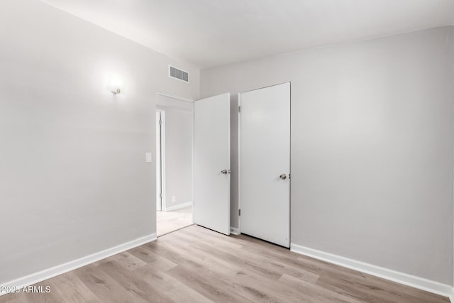 unfurnished bedroom with baseboards, visible vents, and light wood-style floors