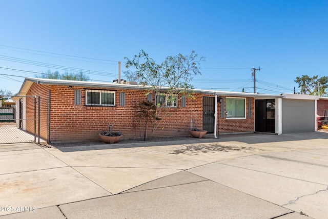 ranch-style home featuring driveway, fence, and brick siding