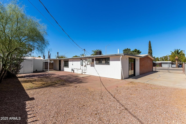 back of property with a patio, fence, and a gate