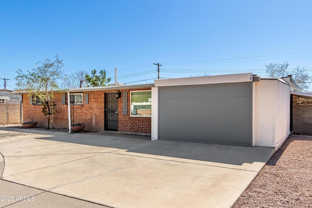 ranch-style home featuring brick siding, driveway, and fence