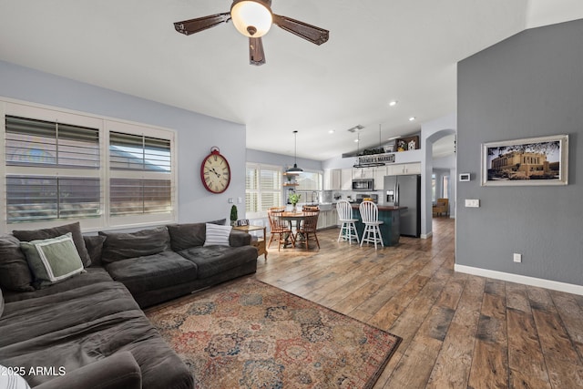 living room featuring hardwood / wood-style floors, vaulted ceiling, and ceiling fan