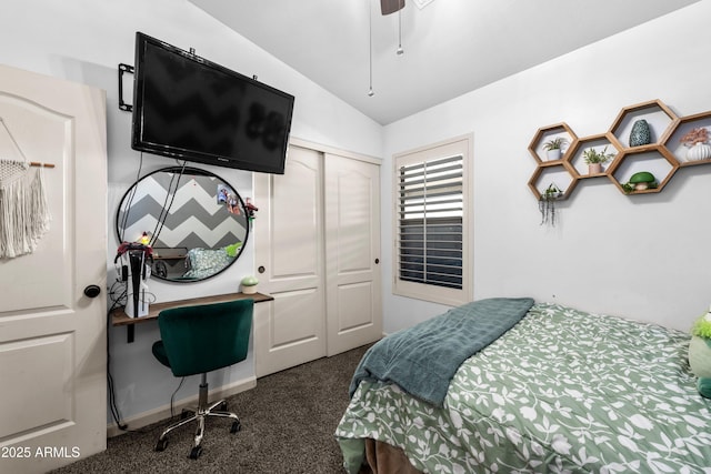 bedroom with ceiling fan, lofted ceiling, dark carpet, and a closet