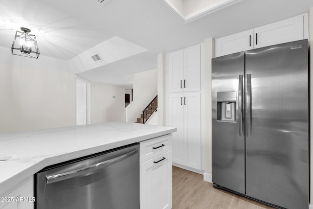 609 E Mesquite Cir Unit D132, Tempe, AZ 85288 - kitchen featuring stainless steel appliances, light wood-style floors, light stone countertops, and white cabinetry