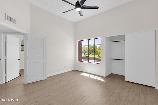 609 E Mesquite Cir Unit D132, Tempe, AZ 85288 - unfurnished bedroom with light wood-style flooring, a towering ceiling, a ceiling fan, and a closet