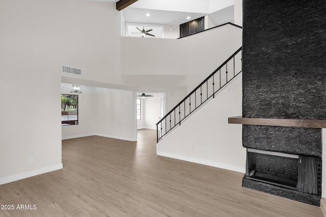 609 E Mesquite Cir Unit D132, Tempe, AZ 85288 - unfurnished living room with a ceiling fan, a high ceiling, wood finished floors, stairway, and a fireplace