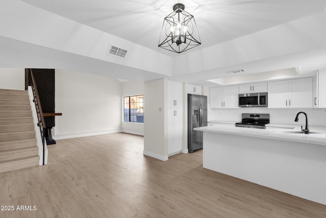 609 E Mesquite Cir Unit D132, Tempe, AZ 85288 - kitchen featuring appliances with stainless steel finishes, open floor plan, light wood-type flooring, white cabinetry, and a high ceiling