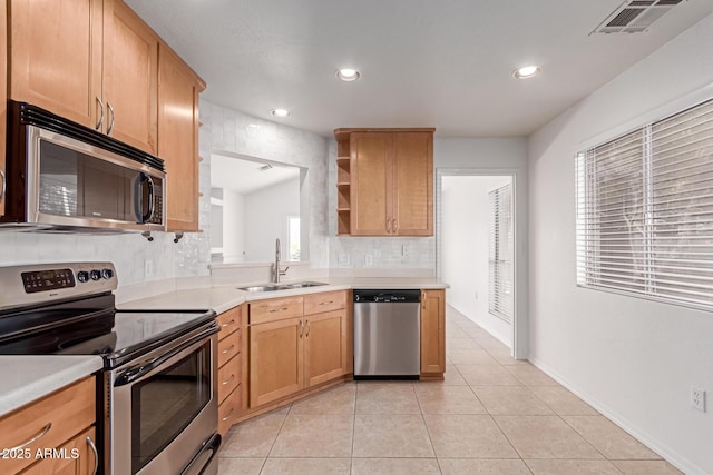 kitchen featuring visible vents, light countertops, light tile patterned flooring, stainless steel appliances, and a sink