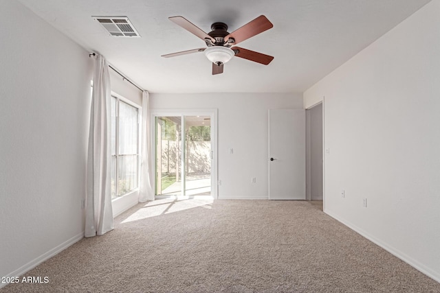 unfurnished room featuring visible vents, light colored carpet, baseboards, and ceiling fan