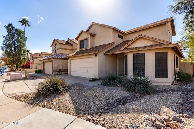 view of front facade featuring stucco siding, an attached garage, and driveway