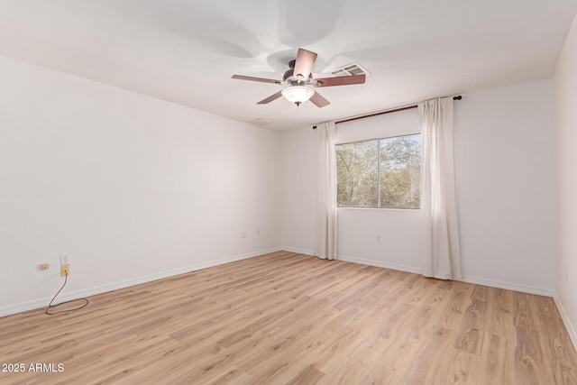 spare room featuring visible vents, baseboards, light wood-type flooring, and a ceiling fan