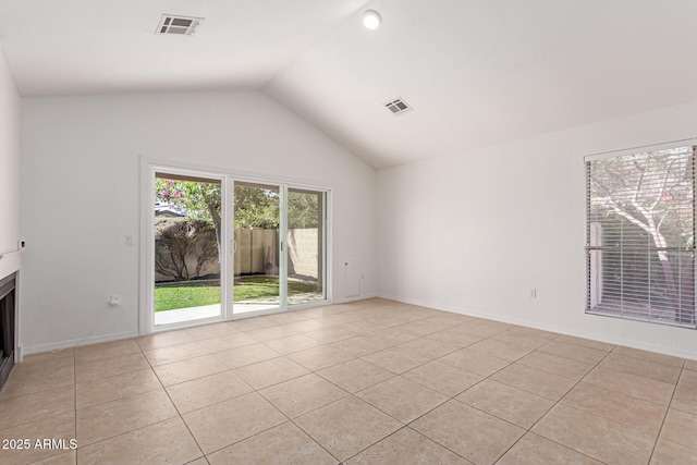 unfurnished living room featuring lofted ceiling, light tile patterned floors, a fireplace, and visible vents