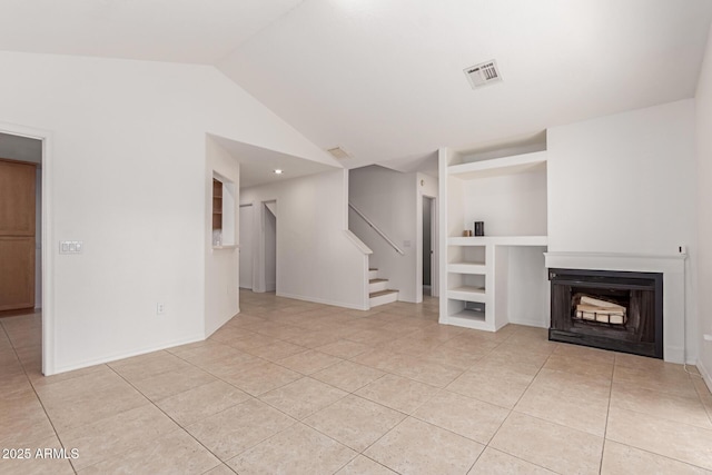 unfurnished living room featuring stairway, built in shelves, visible vents, lofted ceiling, and a fireplace