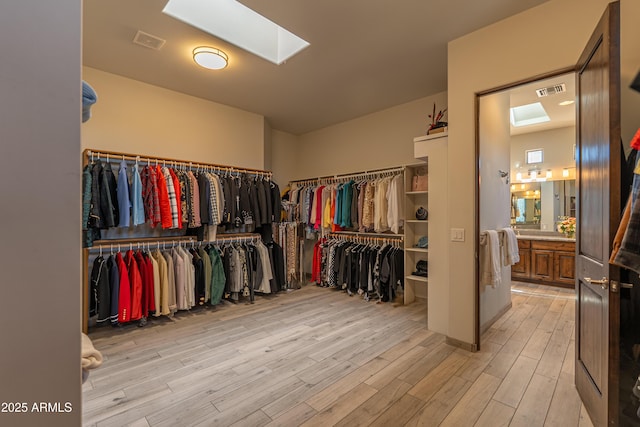 14332 E Bobwhite Way, Scottsdale, AZ 85262 - walk in closet featuring a skylight and light wood finished floors