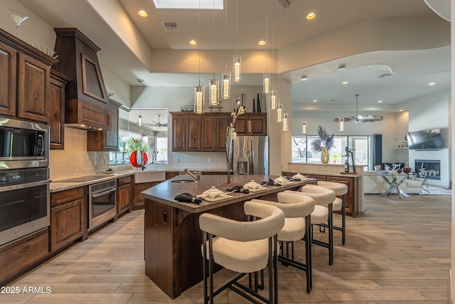 14332 E Bobwhite Way, Scottsdale, AZ 85262 - kitchen with stainless steel appliances, a kitchen island with sink, plenty of natural light, light wood finished floors, and recessed lighting