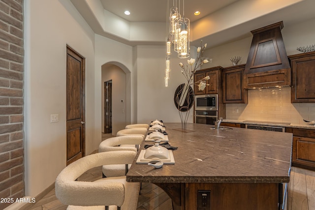 14332 E Bobwhite Way, Scottsdale, AZ 85262 - kitchen with stainless steel appliances, arched walkways, decorative backsplash, dark brown cabinets, and recessed lighting