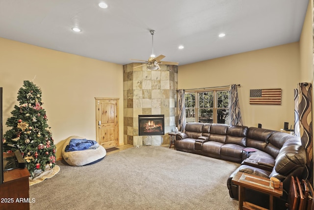 carpeted living room with a fireplace and ceiling fan