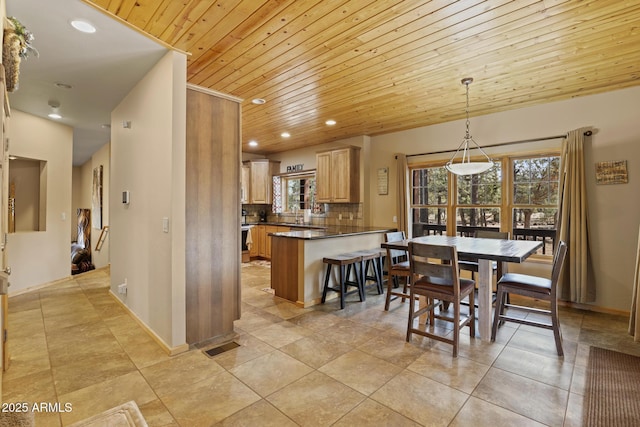 dining area featuring light tile patterned flooring, sink, and wooden ceiling