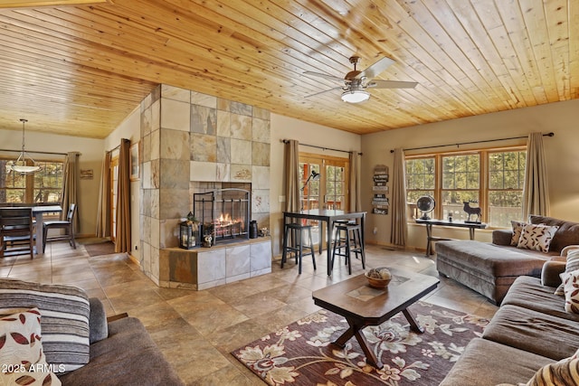 tiled living room with wood ceiling, a fireplace, and ceiling fan